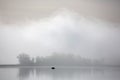 Misty autumn morning. Fishermen on the river in a boat