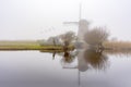 Misty and calm windmill sunrise Royalty Free Stock Photo