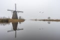 Misty and calm windmill sunrise Royalty Free Stock Photo