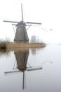 Misty and calm windmill sunrise Royalty Free Stock Photo