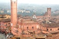 Misty city with 14th century tower Torre del Mangia, Siena of Italy. Tuscany city roofs and old houses Royalty Free Stock Photo