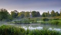Misty dawn light on Stoke Charity village pond and St Michael`s Church, Hampshire, UK Royalty Free Stock Photo
