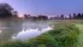 Misty dawn light on Stoke Charity village pond and St Michael`s Church, Hampshire, UK Royalty Free Stock Photo