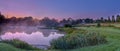 Misty dawn light on Stoke Charity village pond and St Michael`s Church, Hampshire, UK Royalty Free Stock Photo