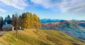 Misty early daybreak in autumn mountain and wooden chapel on mountain top (Jasynja Village, Carpathian Royalty Free Stock Photo