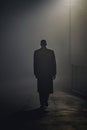 Mysterious African american man wearing a long trench coat in the fog. Noire detective. Cultural and Artistic Flourishing era. Royalty Free Stock Photo