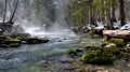 Misty Forest Stream with Snow and Moss Covered Rocks Royalty Free Stock Photo