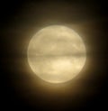 A misty full moon with drifting clouds