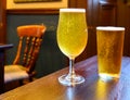 Misty glasses with two pints of cold Scotch ale, amber pale ale, lager draft beer in English pub