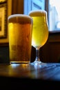 Misty glasses with two pints of cold Scotch ale, amber pale ale, lager draft beer in English pub