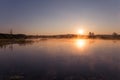 Misty Golden Sunrise Reflecting over Lake in Spring Royalty Free Stock Photo