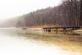 Misty lake in the middle of the forest and old wooden bridge Royalty Free Stock Photo