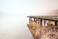 Misty lake in the middle of the forest and old wooden bridge Royalty Free Stock Photo