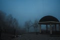 misty landscape with a gazebo by river on an autumn morning in the fog mist