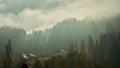 Misty landscape of mountain village at autumn. Cloudy sky with sun rays over forest Royalty Free Stock Photo