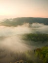 Misty melancholic morning. View into long deep valley full of fresh spring mist. Landscape within daybreak after rainy night Royalty Free Stock Photo