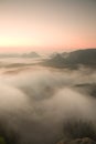 Misty melancholic morning. View into long deep valley full of fresh spring mist. Landscape within daybreak after rainy night Royalty Free Stock Photo