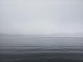 Misty morning background in the sea. Fog over lake wave water. Calm beach view. Tranquil empty nature landscape with gloomy sky.