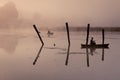 A misty morning by the lake. Small fishing boat at the lake. Royalty Free Stock Photo