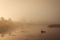 A misty morning by the lake. Small fishing boat at the lake.