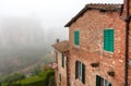 Misty morning in old city with historical houses of Siena, Tuscany. Brick homes in Italy Royalty Free Stock Photo