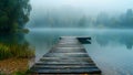 A misty morning over the lake with an old wooden bridge