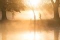 Early morning mist and fog over lake with passers by Royalty Free Stock Photo