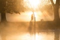 Early morning mist and fog over lake with passers by Royalty Free Stock Photo