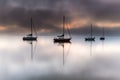Misty Morning Sunrise Waterscape with Boats Royalty Free Stock Photo