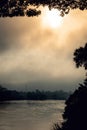 Misty morning with tree silhouette and water on river bank in Kuala Kangsar, Perak Royalty Free Stock Photo