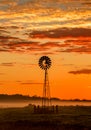 Windmill and misty morning across rural farmland fields Royalty Free Stock Photo