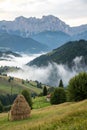 Misty mountain landscape with fog and haystack Royalty Free Stock Photo