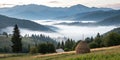 Misty mountain landscape with fog and haystack Royalty Free Stock Photo