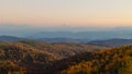 Misty Mountain Mornings: Panoramic Autumn Forest with Blue Sky and Sunrise Haze