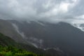 Misty mountains with dramatic cloudy sky at morning in rainy day Royalty Free Stock Photo