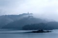 Misty mountains by Sun Moon Lake on a foggy morning, with a pagoda on the distant mountaintop Royalty Free Stock Photo