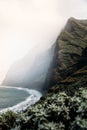 Misty ocean cliff under cloudy skies.