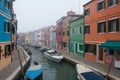 Misty picture of street with colored houses in fog, italian island Burano, province of Venice, Italy, foggy weather