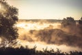 Misty rural landscape during golden hour at river bank in the early morning Royalty Free Stock Photo