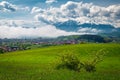 Misty spring landscape with green fields and snowy mountains, Romania Royalty Free Stock Photo