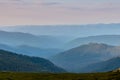 Misty spring mountain hills landscape. Layers of green mountains and hills in the haze during sunset. Royalty Free Stock Photo