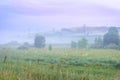 Misty Summer Sunrise in the Mountains: Tall Grass, Thick Fog, Trees, Power Line Towers and Dramatic Purple Clouds. Green Energy, Royalty Free Stock Photo