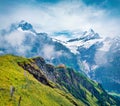 Misty summer view of Wetterhorn peaks . Picturesque morning scene of Swiss Bernese Alps, Switzerland