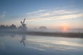 Misty sunrise over river and windmill Royalty Free Stock Photo