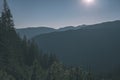 misty sunrise in Slovakian Tatra mountains with light lanes in fog over dark forest. autumn in hiking trails - vintage old film