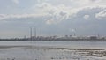 Misty view from across the water on Poolberg peninsula, with the chimneys of the power generation station , view from the beach