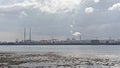 Misty view from across the water on Poolberg peninsula, with the chimneys of the power generation station , view from the beach