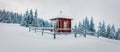 Misty winter panorama with small chapel in the mountain village. Frosty outdoor scene of the Carpathians, Bukovel ski resort Royalty Free Stock Photo