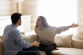 Angry worried young spouses quarreling arguing at home