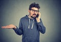 Upset young man talking on cellphone feeling annoyed and frustrated Royalty Free Stock Photo